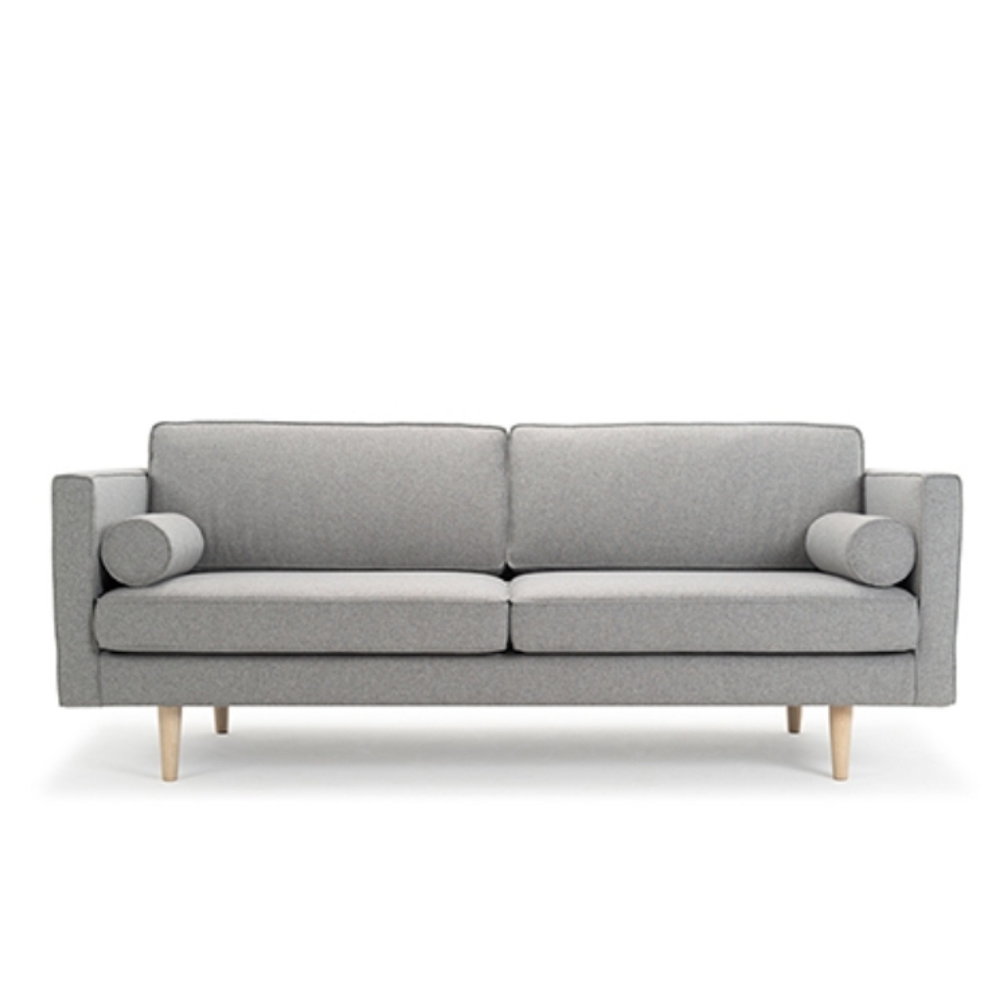 Grey Fabric Couch With Two Round Grey Cushions In The Corners.